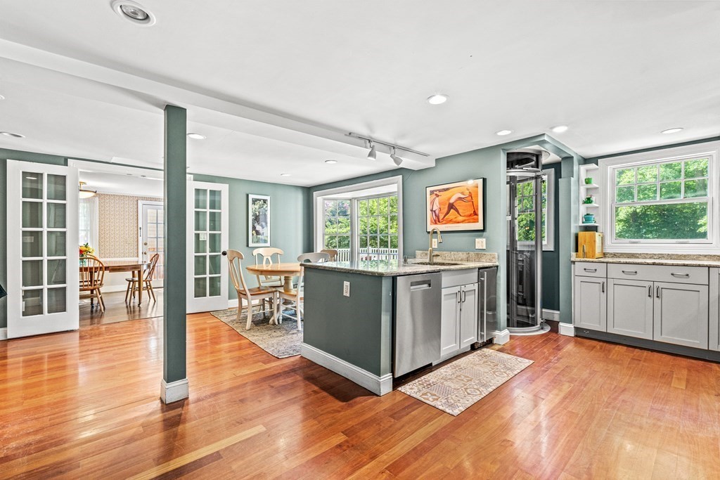 288 Mill Street Newton, MA 02460 - Photo 8 of 35 a kitchen with stainless steel appliances granite countertop a refrigerator oven stove a sink and a dining table with wooden floor