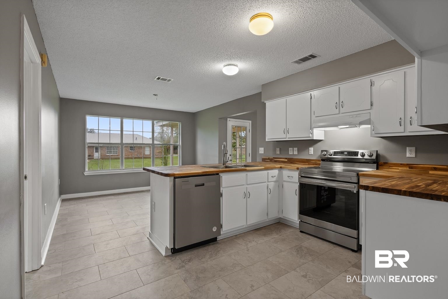 16418 Avent Lane Foley, AL 36535 - Photo 21 of 30 Kitchen with stainless steel appliances, butcher block counters, kitchen peninsula, and a textured ceiling