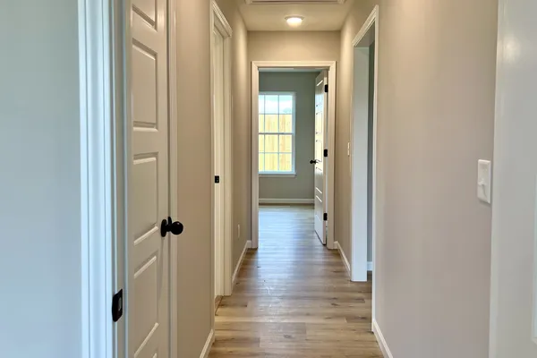 a view of a hallway with wooden floor