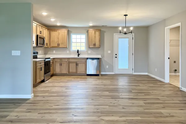 a large kitchen with stainless steel appliances granite countertop a stove and a refrigerator