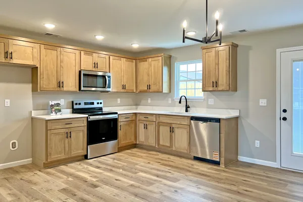 a kitchen with stainless steel appliances granite countertop a sink and microwave