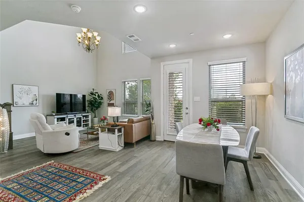 a living room with furniture a flat screen tv and a large window