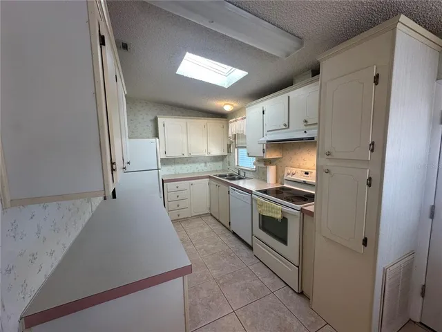 a kitchen with stainless steel appliances a sink stove and refrigerator