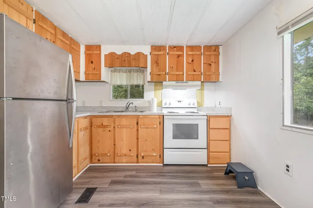 a kitchen with a refrigerator and white cabinets