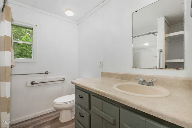 a bathroom with a granite countertop sink a toilet and a mirror