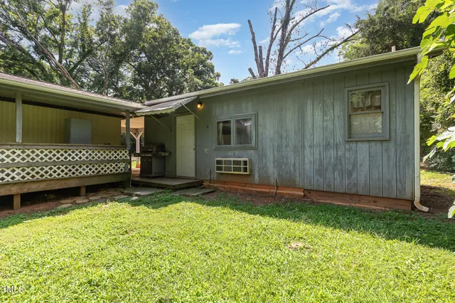 a view of a backyard with a large tree and wooden fence