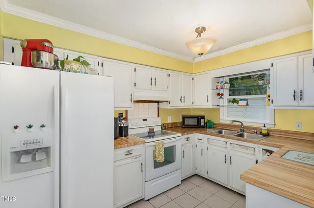a kitchen with white cabinets and white appliances