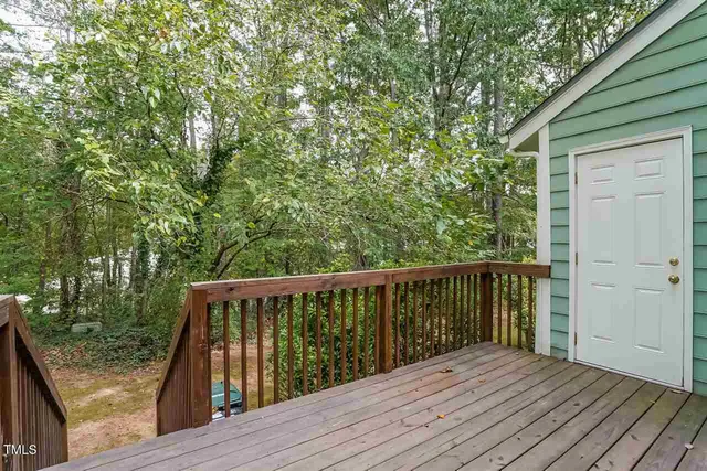 a balcony with wooden floor and yard in the back