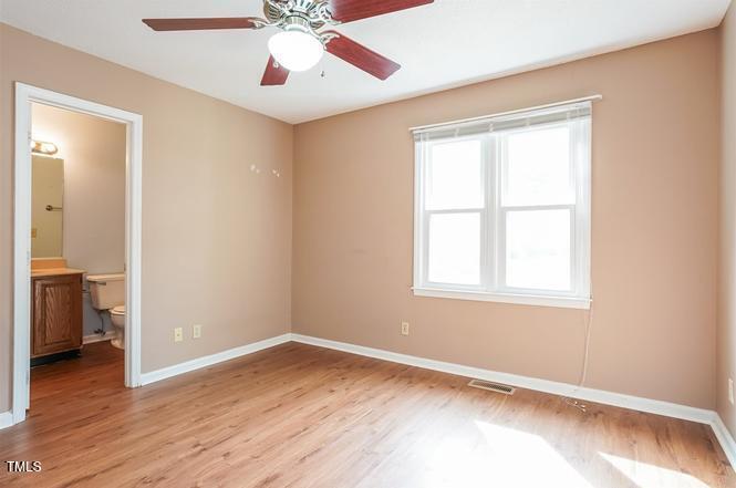 551 Oak Run Drive Raleigh, NC 27606 - Photo 8 of 13 a view of an empty room with wooden floor and a window