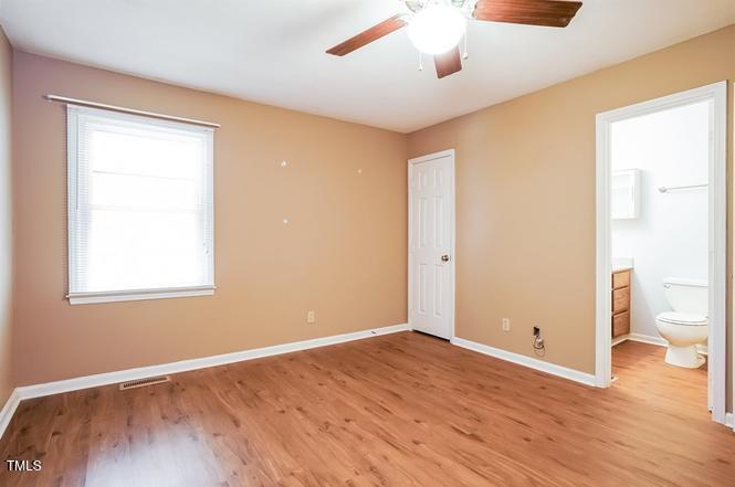 551 Oak Run Drive Raleigh, NC 27606 - Photo 9 of 13 an empty room with wooden floor and a window