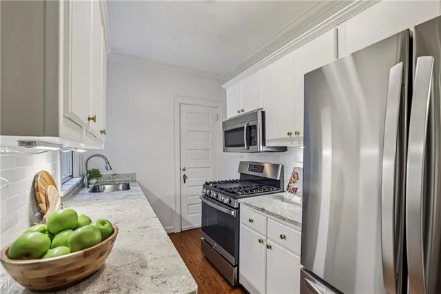 a kitchen with stainless steel appliances a sink a stove and a refrigerator