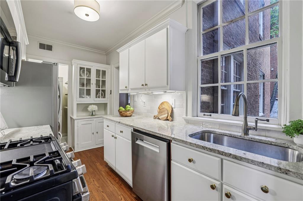 8 Collier Road Northwest, Unit A1 Atlanta, GA 30309 - Photo 9 of 31 a kitchen with a sink stove and cabinets