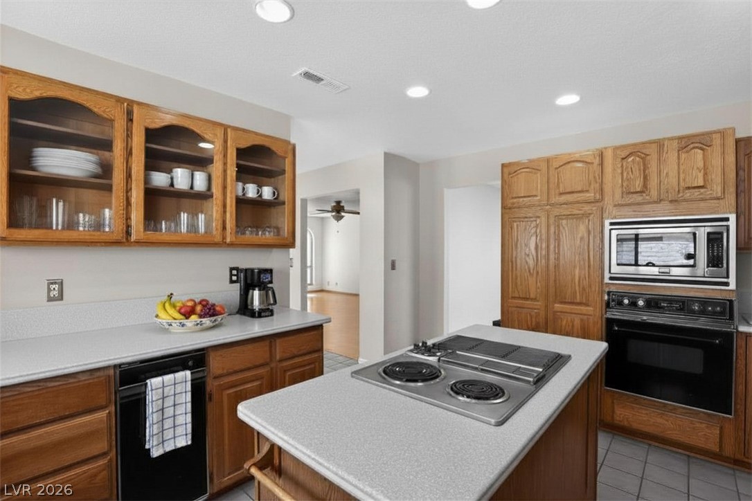 3698 Laughlin Boulevard Laughlin, NV 89029 - Photo 26 of 49 A functional kitchen features wood cabinetry and a convenient center island cooktop, flowing into an open living area.