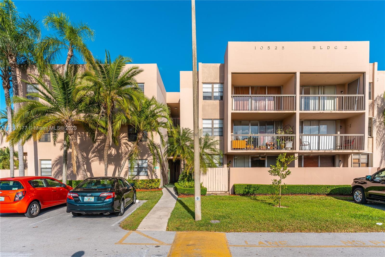 a front view of a house with a garden and tree