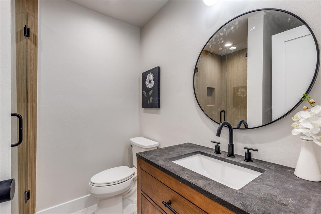 17119 Skelton Place Dallas, TX 75248 - Photo 25 of 32 a bathroom with a granite countertop toilet sink and mirror