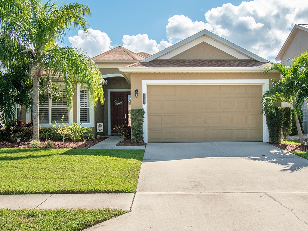 119 Amherst Lane Sebastian, FL 32958 - Photo 1 of 35 a view of a brick house with a yard potted plants and palm trees