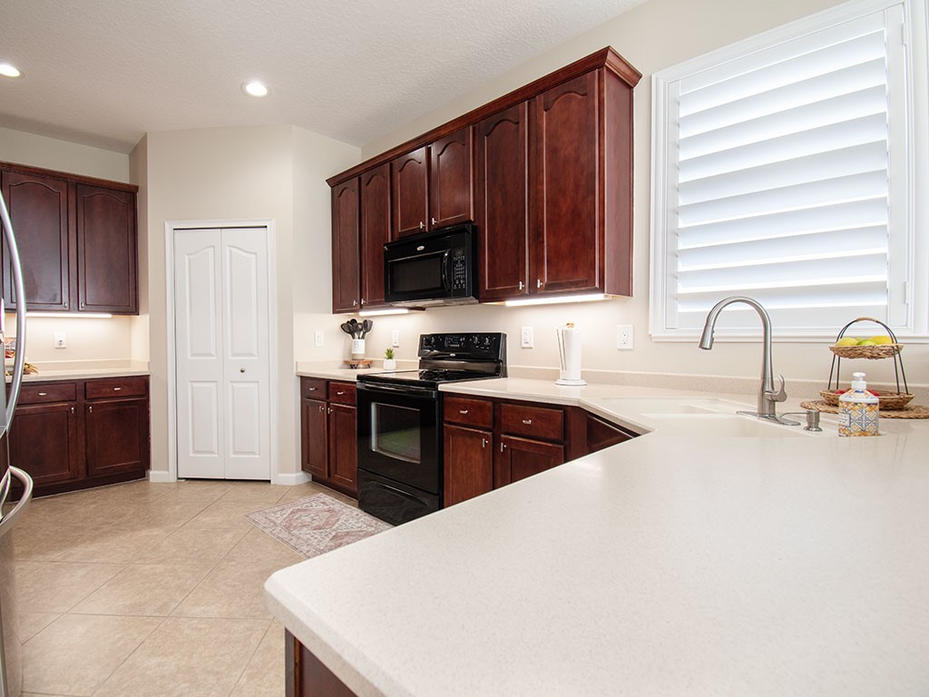119 Amherst Lane Sebastian, FL 32958 - Photo 13 of 35 a kitchen with kitchen island granite countertop a stove top oven a sink dishwasher and a refrigerator with wooden cabinets