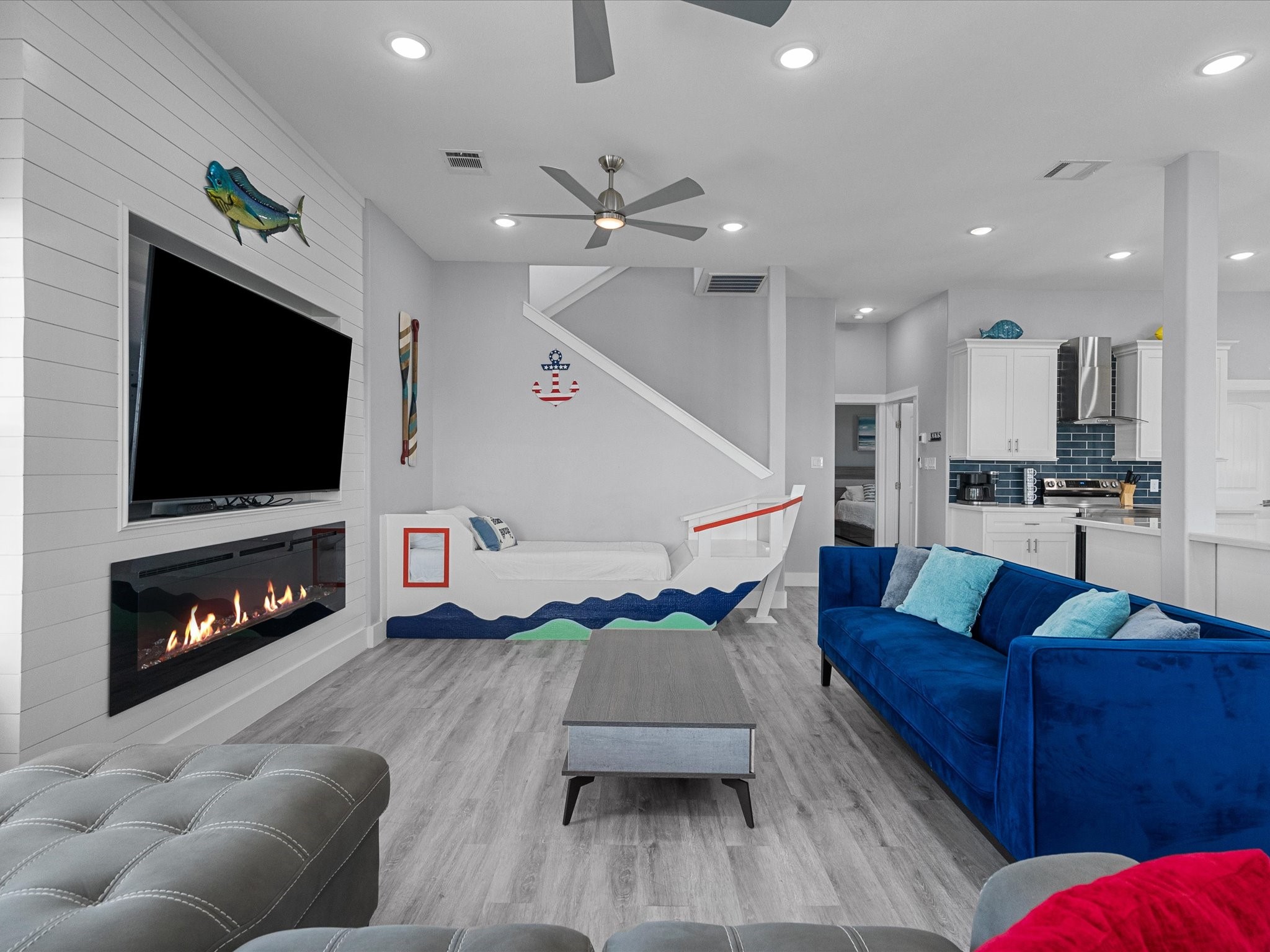718 Beach Drive Surfside Beach, TX 77541 - Photo 22 of 49 Experience modern elegance in this bedroom with light gray walls, wood-style flooring, and a ceiling fan with recessed lighting. Enjoy the comfort of a large bed with neutral bedding and convenient access to an en-suite bathroom.