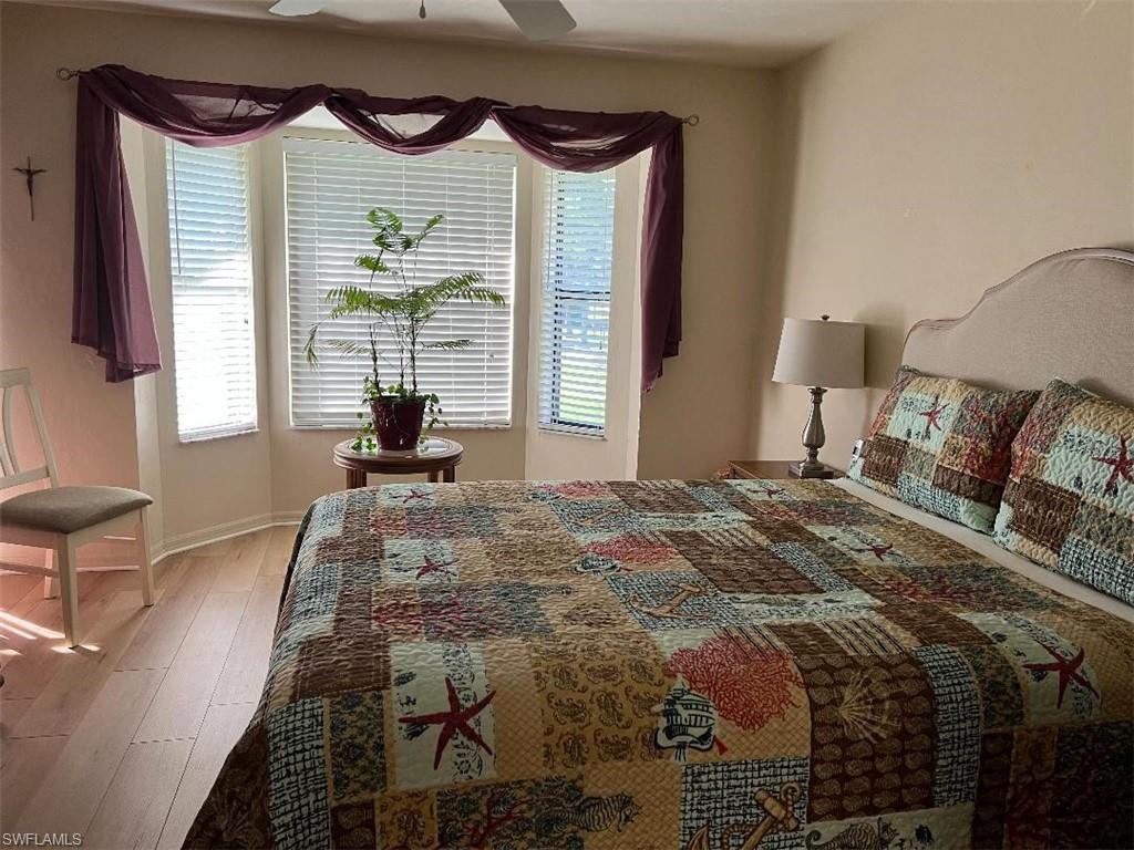 501 Veranda Way, Unit G204 Naples, FL 34104 - Photo 5 of 7 a bedroom with a bed and a painting on the wall