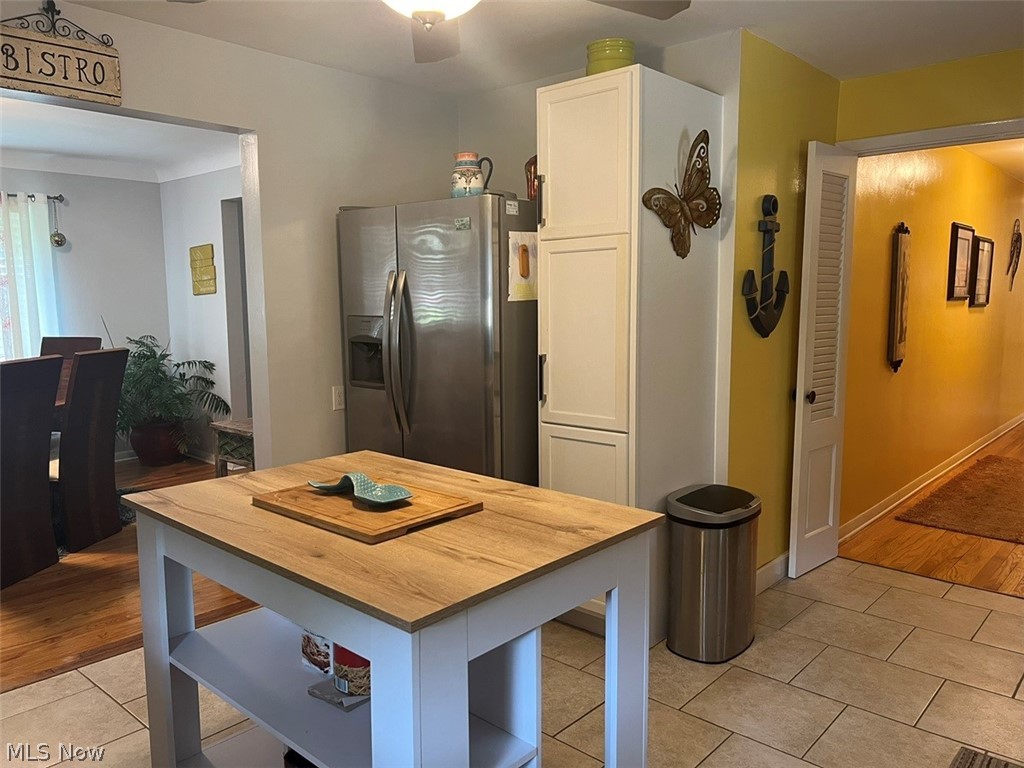 759 Truesdale Road Youngstown, OH 44511 - Photo 12 of 37 Kitchen featuring white cabinetry, light tile patterned floors, stainless steel refrigerator with ice dispenser, and ceiling fan
