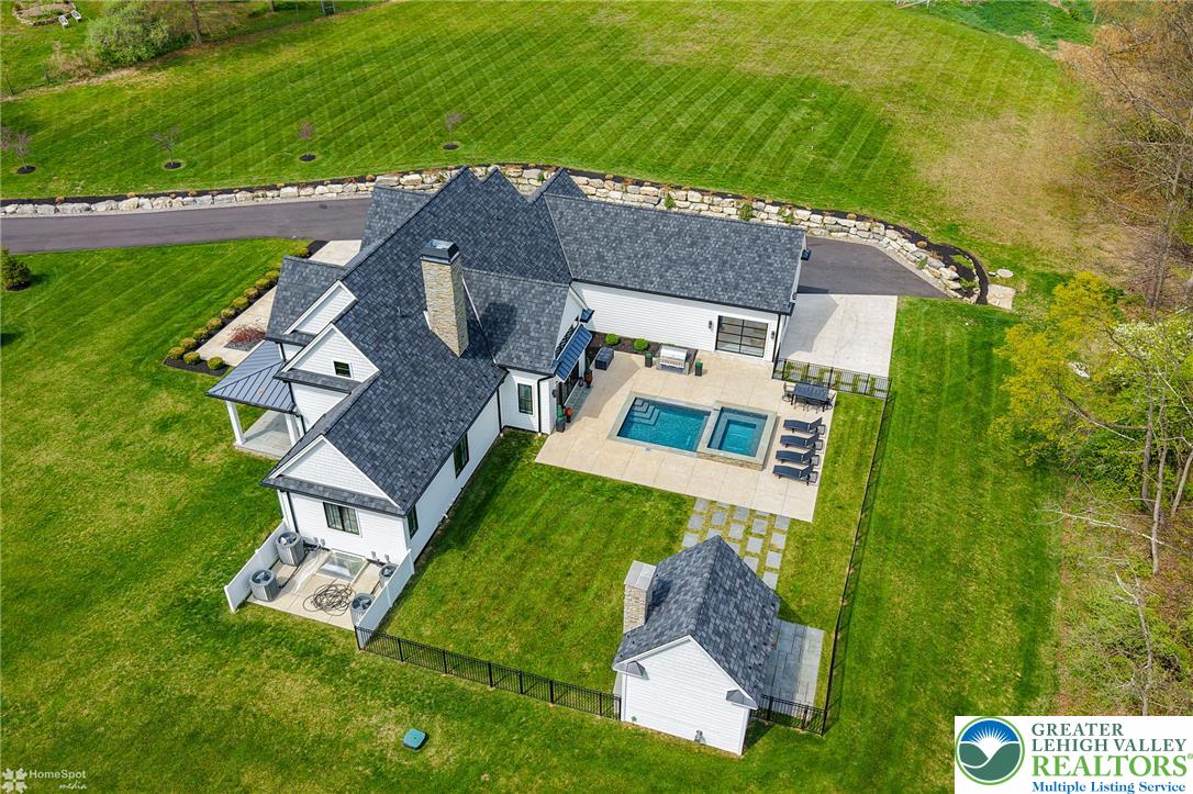 4850 West Hopewell Road Center Valley, PA 18034 - Photo 29 of 96 An aerial perspective reveals a modern residence with a private pool and a detached outbuilding, nestled within lush green grounds.