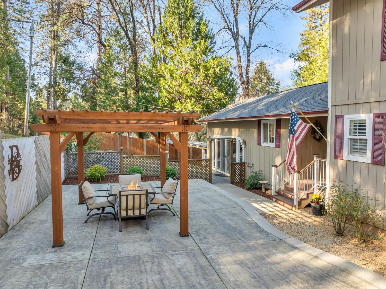 10092 Smith Road Grass Valley, CA 95949 - Photo 13 of 58 a view of a patio with a table and chairs under an umbrella with wooden fence