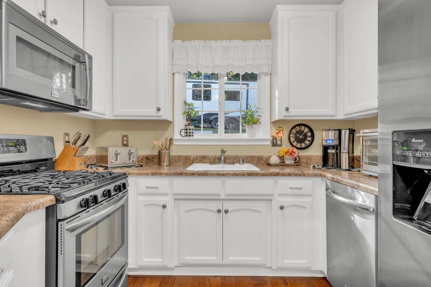 10092 Smith Road Grass Valley, CA 95949 - Photo 23 of 58 a kitchen with stainless steel appliances granite countertop a stove a sink and a white cabinets