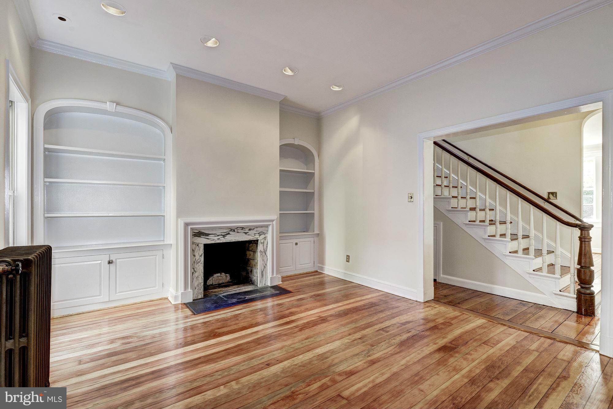 3217 Volta Place Northwest Washington, DC 20007 - Photo 5 of 21 a view of an empty room with wooden floor fireplace and a window