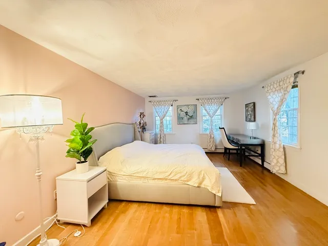 a living room with a bed furniture and a potted plant
