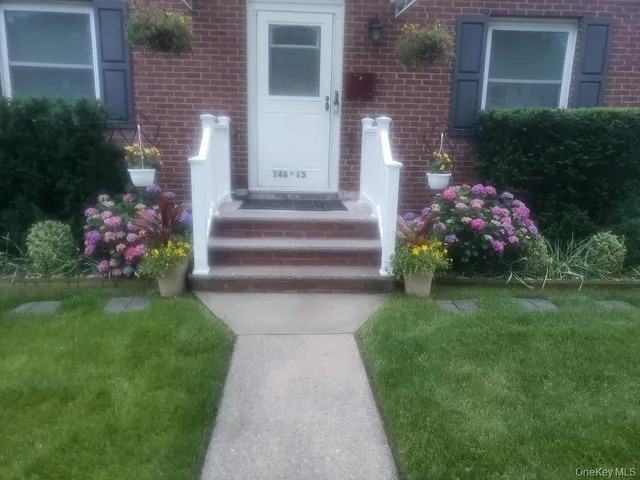 a front view of a house with a garden and flowers