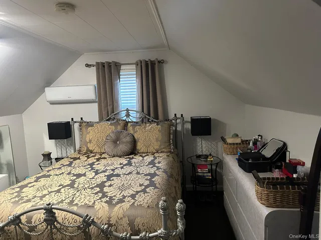 a bedroom with a bed and a tv on the dresser