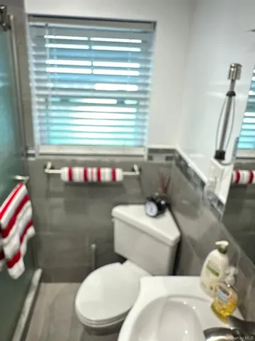 a white toilet sitting next to a bathroom sink and a window