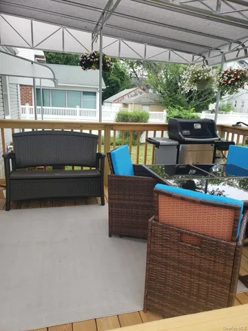a view of a roof deck with couches and wooden floor