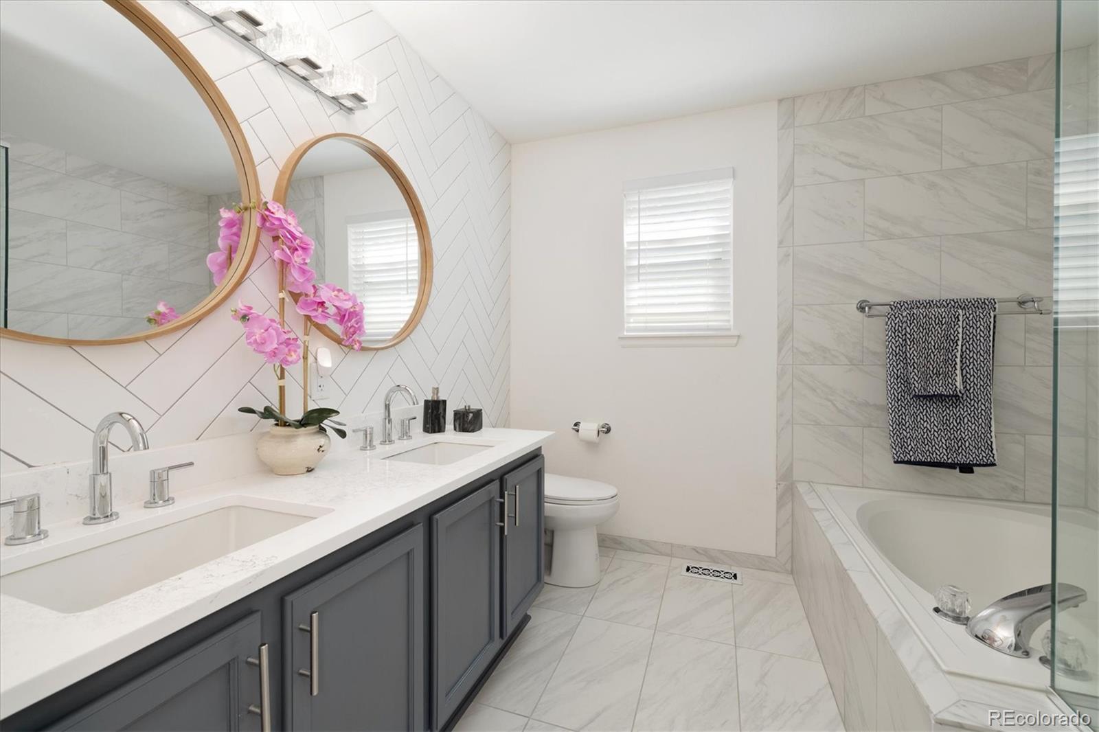 1191 Riddlewood Lane Highlands Ranch, CO 80129 - Photo 19 of 33 a spacious bathroom with a bathtub sink and mirror