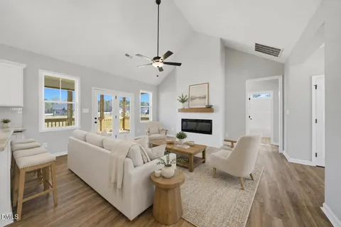 a living room with furniture a fireplace and a chandelier