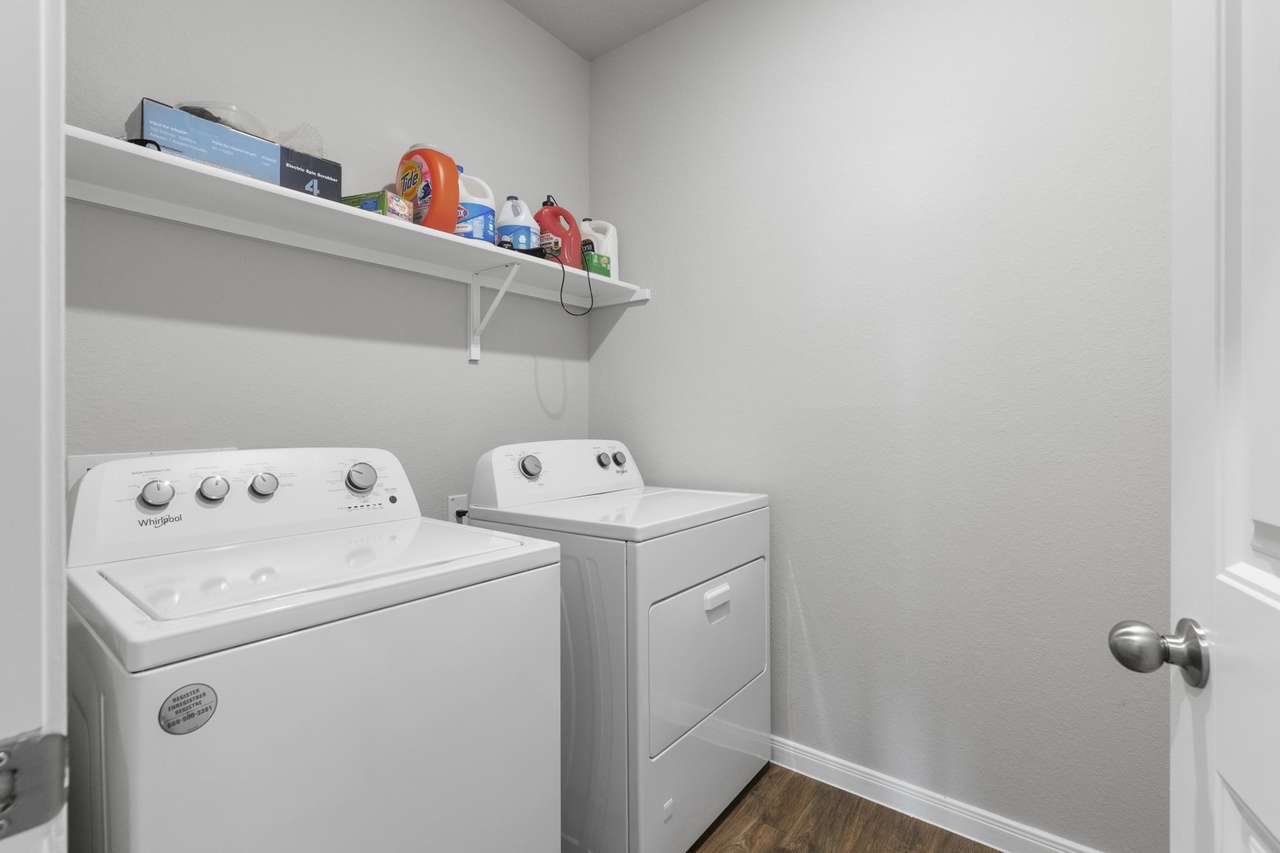 212 Apache Plum Drive Kyle, TX 78640 - Photo 18 of 21 Laundry room with dark wood finished floors and washer and clothes dryer
