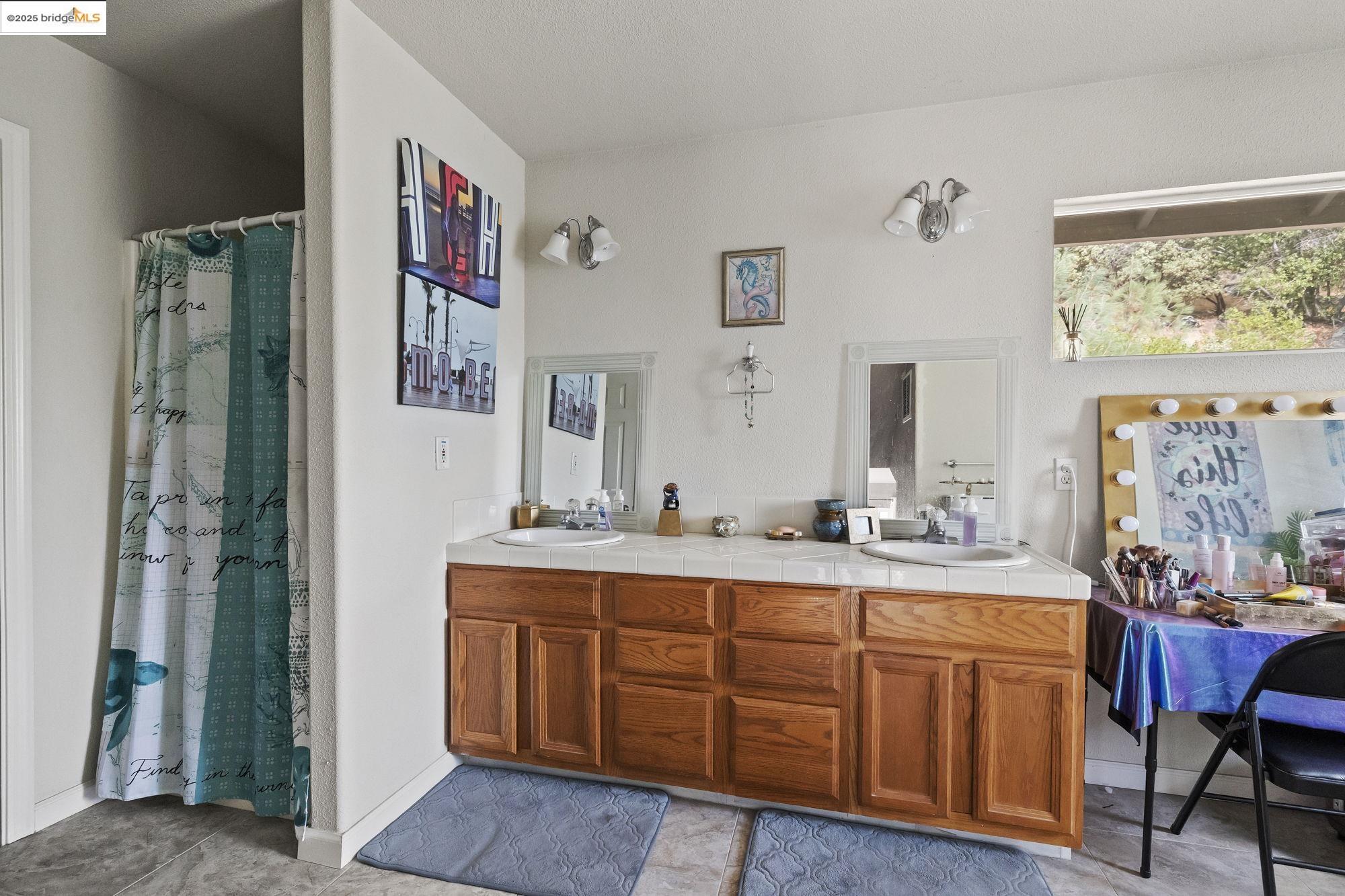20588 Upper Hillview Drive Sonora, CA 95370 - Photo 15 of 42 a spacious bathroom with a double vanity sink a two mirror a window and a shower