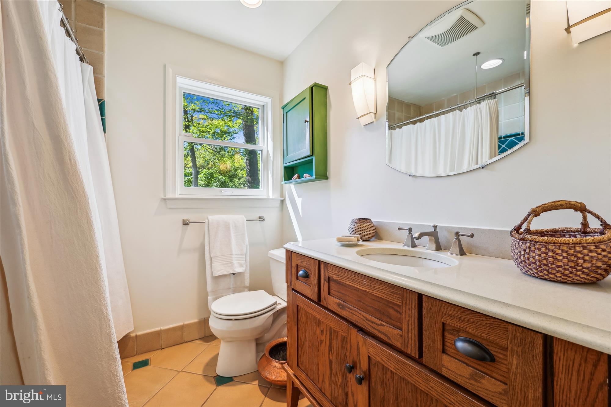 10606 Mantz Road Silver Spring, MD 20903 - Photo 36 of 72 a bathroom with a toilet a sink a mirror and a window