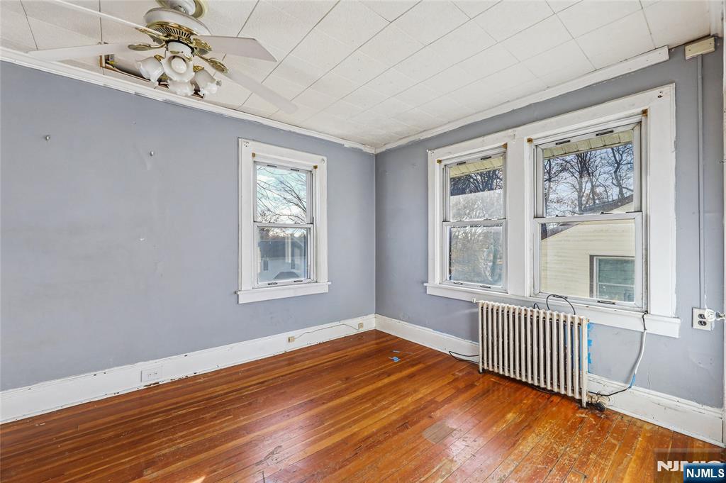 109 Luke Avenue Bergenfield, NJ 07621 - Photo 13 of 16 a view of an empty room with a window and wooden floor