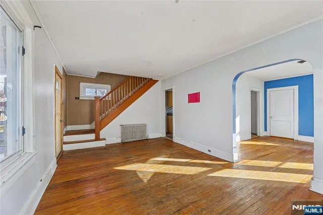 a view of a livingroom with wooden floor and stairs