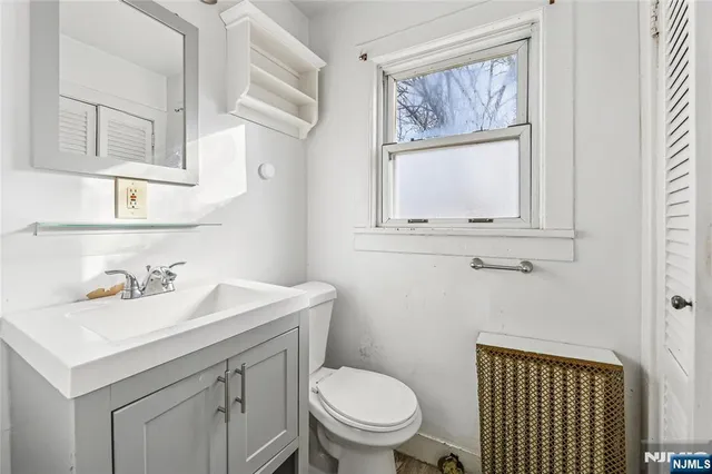 a bathroom with a sink a toilet and a mirror