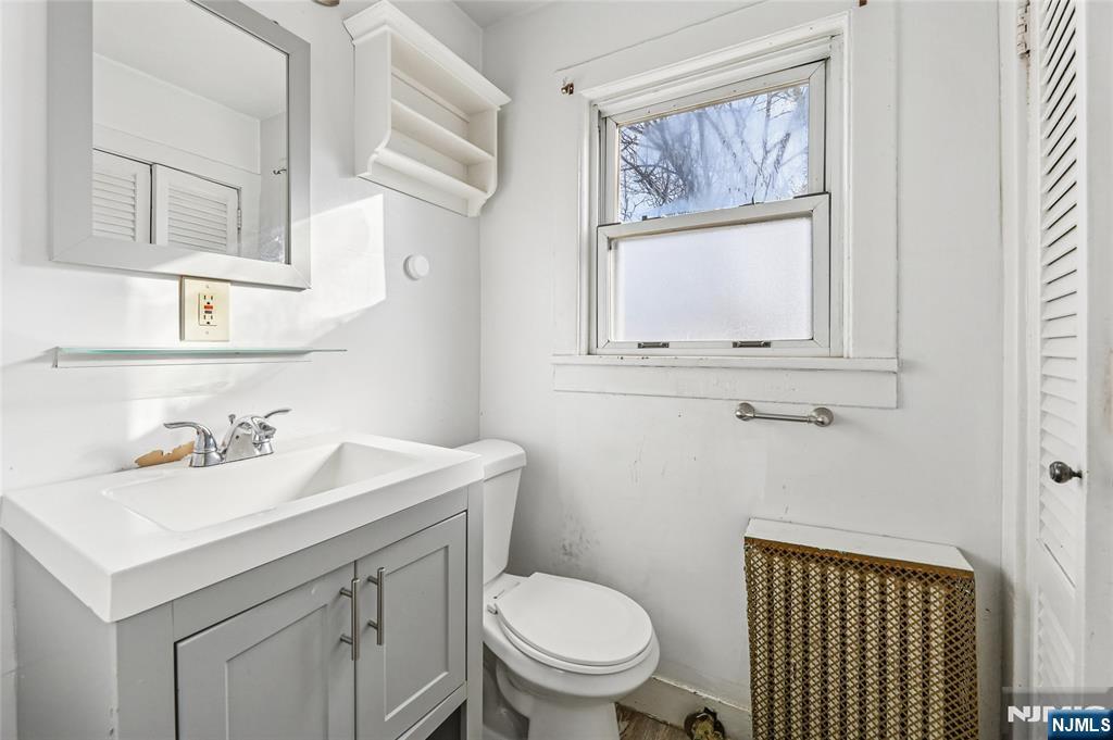 109 Luke Avenue Bergenfield, NJ 07621 - Photo 10 of 16 a bathroom with a sink a toilet and a mirror
