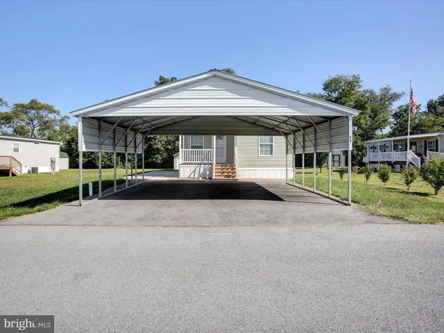 a front view of a house with a yard and potted plants