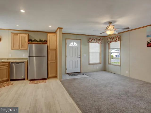 a kitchen with a refrigerator a microwave a stove and a window
