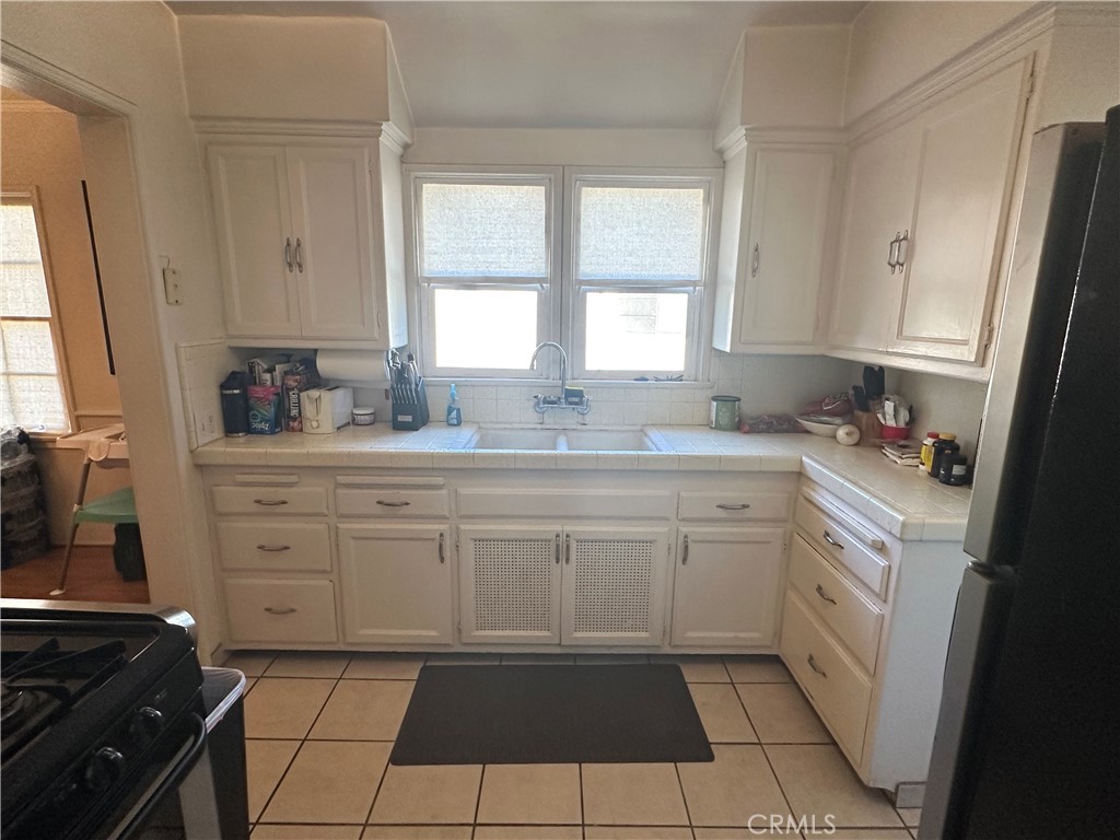 4056 Creed Avenue Los Angeles, CA 90008 - Photo 10 of 13 a kitchen with white cabinets appliances a sink and a window