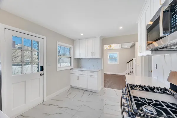 a kitchen with a stove and white cabinets