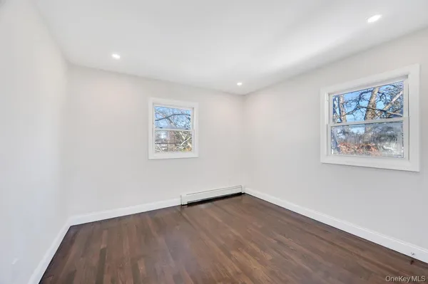 an empty room with wooden floor and window