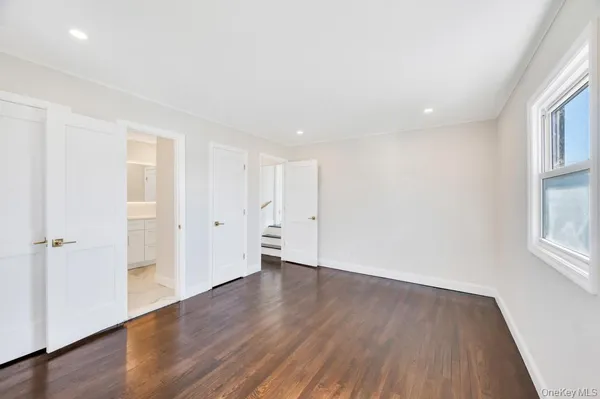 an empty room with wooden floor and a window