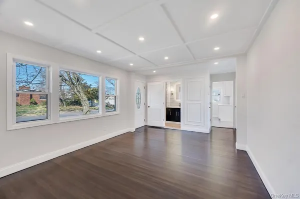 an empty room with wooden floor and window