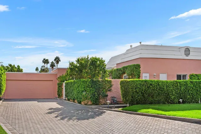 a house with green field in front of it